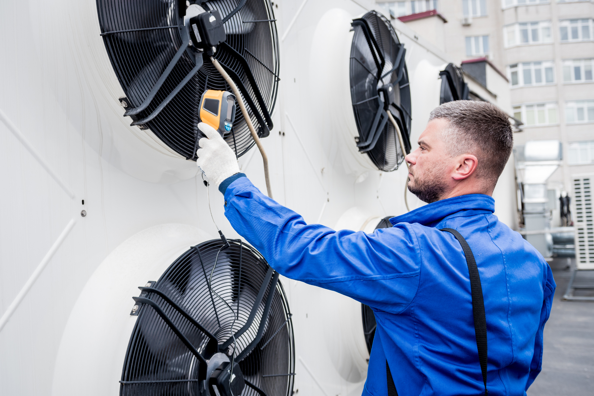Technician uses a thermal imaging infrared thermometer to check the condensing unit heat exchanger